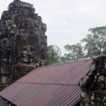 Monkeys looking at a huge face at the Bayon temple Monkeys looking at a huge face at the Bayon temple