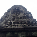 A large face above intricate carvings at the Bayon temple A large face above intricate carvings at the Bayon temple